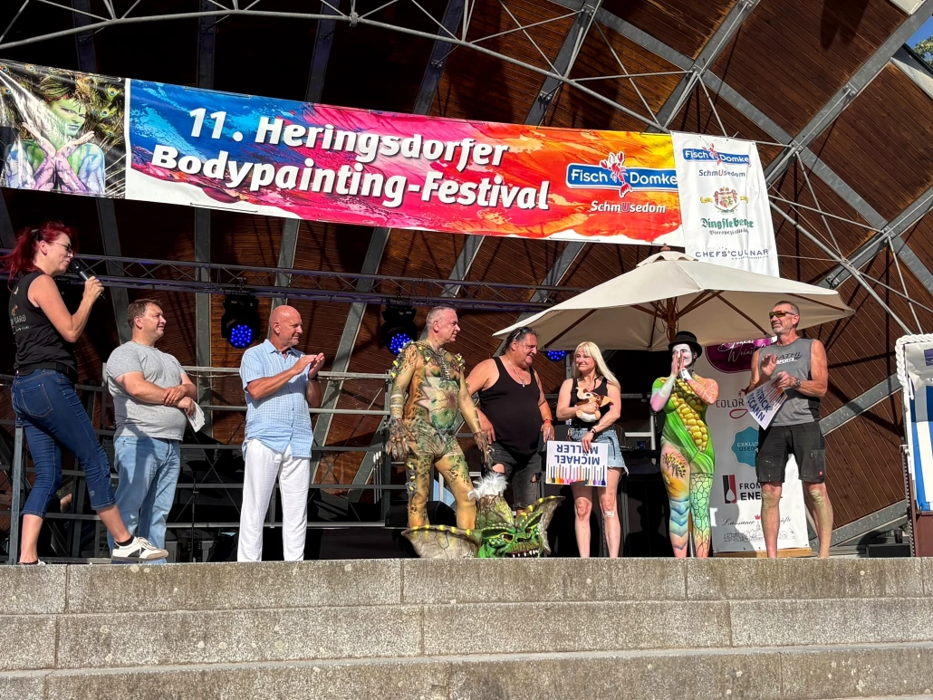 Mehrere Beteiligte stehen während eines Programmpunkts gemeinsam auf der Bühne