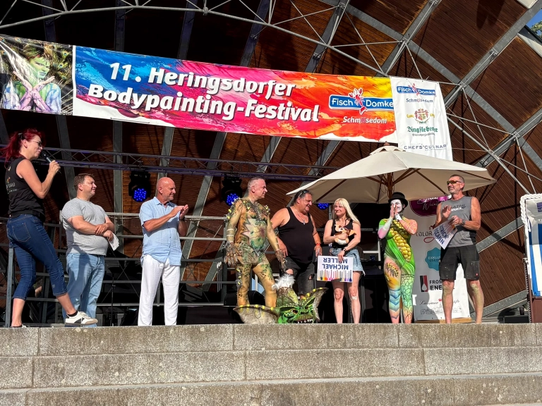 Mehrere Beteiligte stehen während eines Programmpunkts gemeinsam auf der Bühne